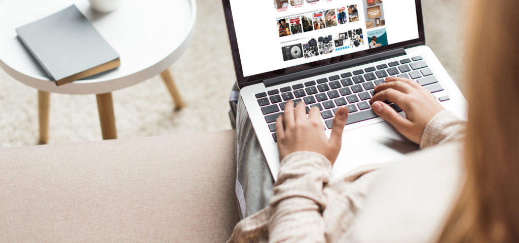 view from above of a woman sitting on a chair shopping on a laptop