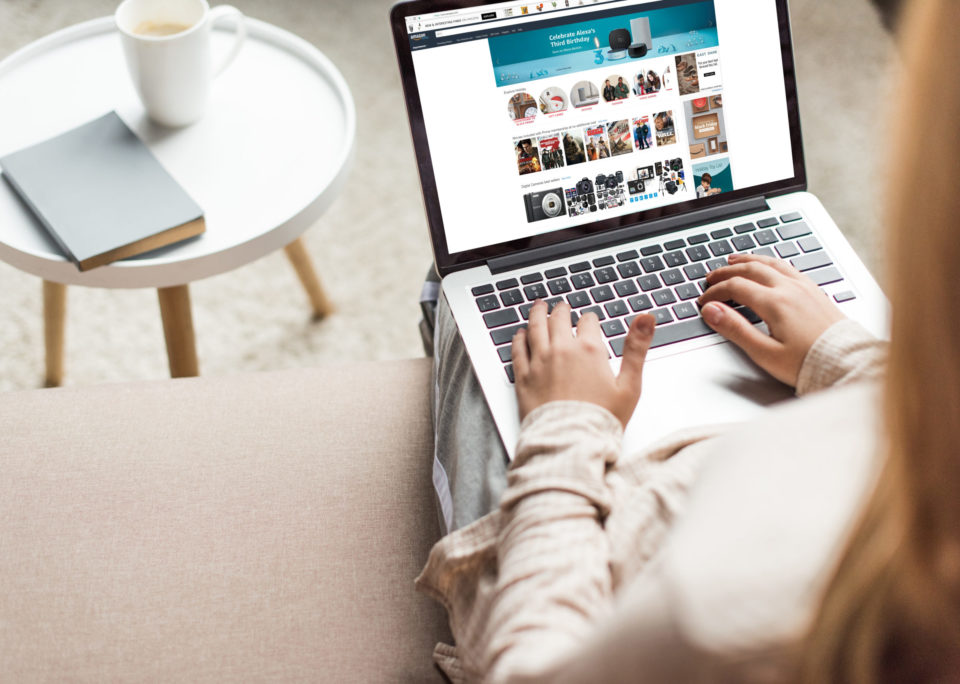 view from above of a woman sitting on a chair shopping on a laptop