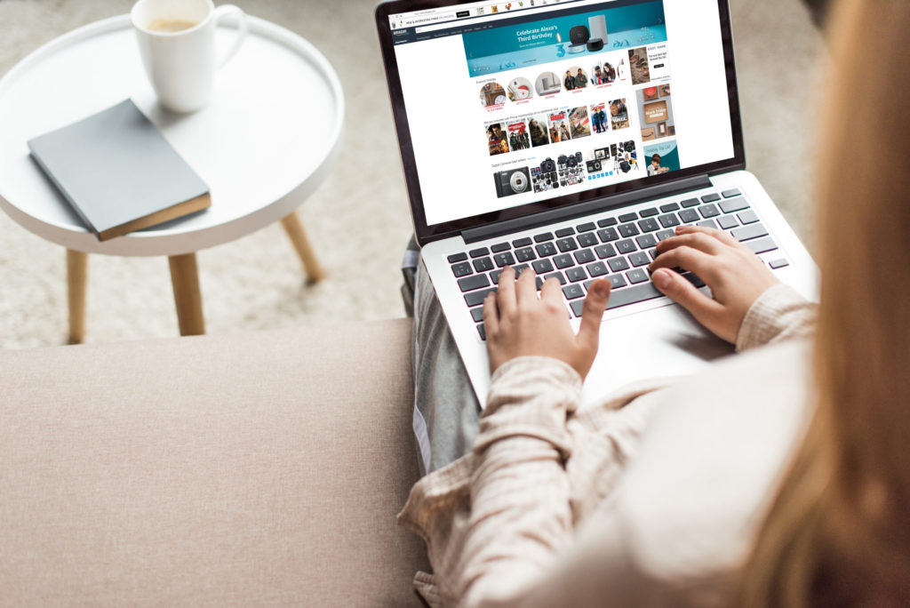 view from above of a woman sitting on a chair shopping on a laptop